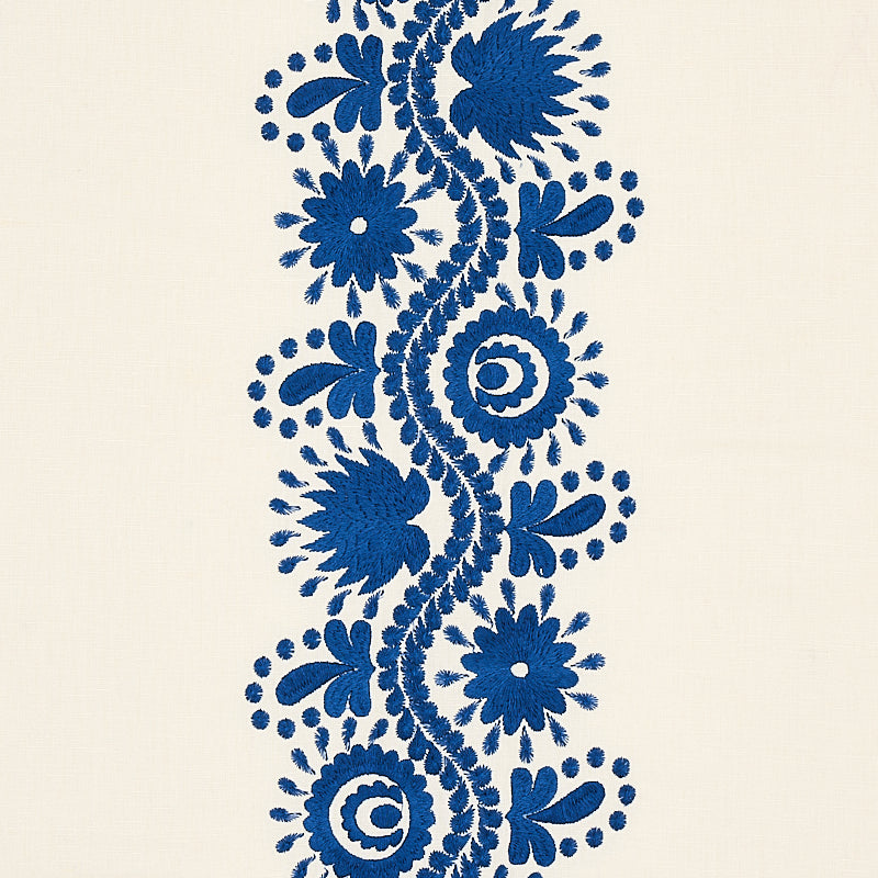 Blue floral embroidery border on cream fabric, vertical scroll of flowers and spirals for decorative trim.