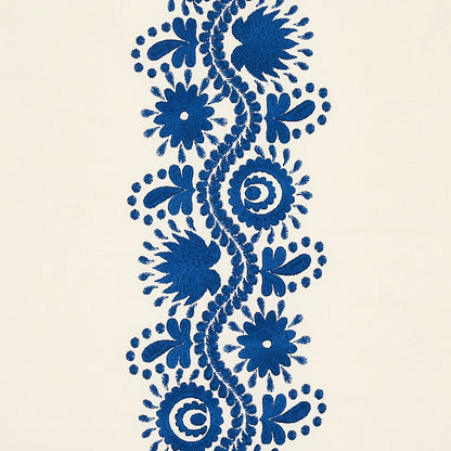 Blue floral embroidery border on cream fabric, vertical scroll of flowers and spirals for decorative trim.