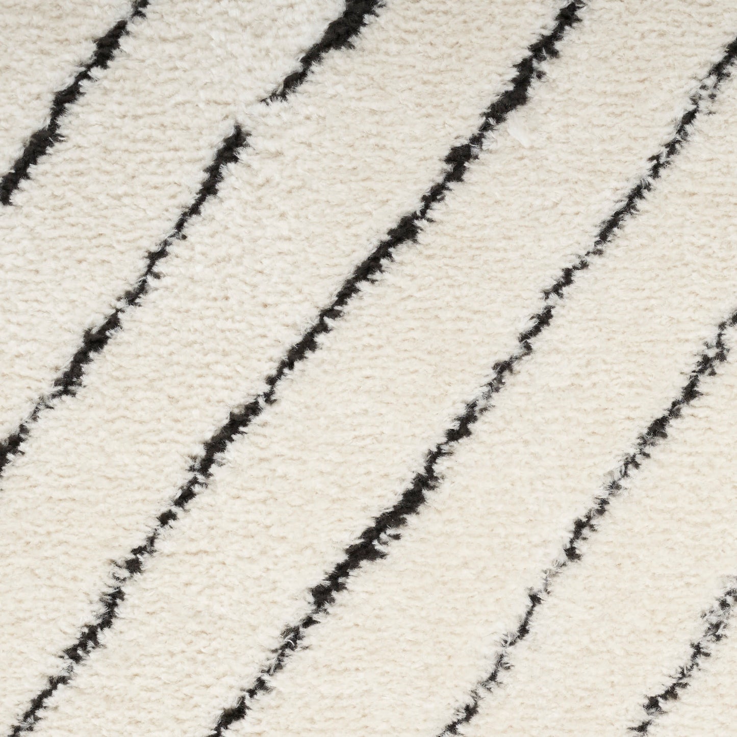 Cream shag rug with slim black diagonal stripes; plush texture and modern geometric design.