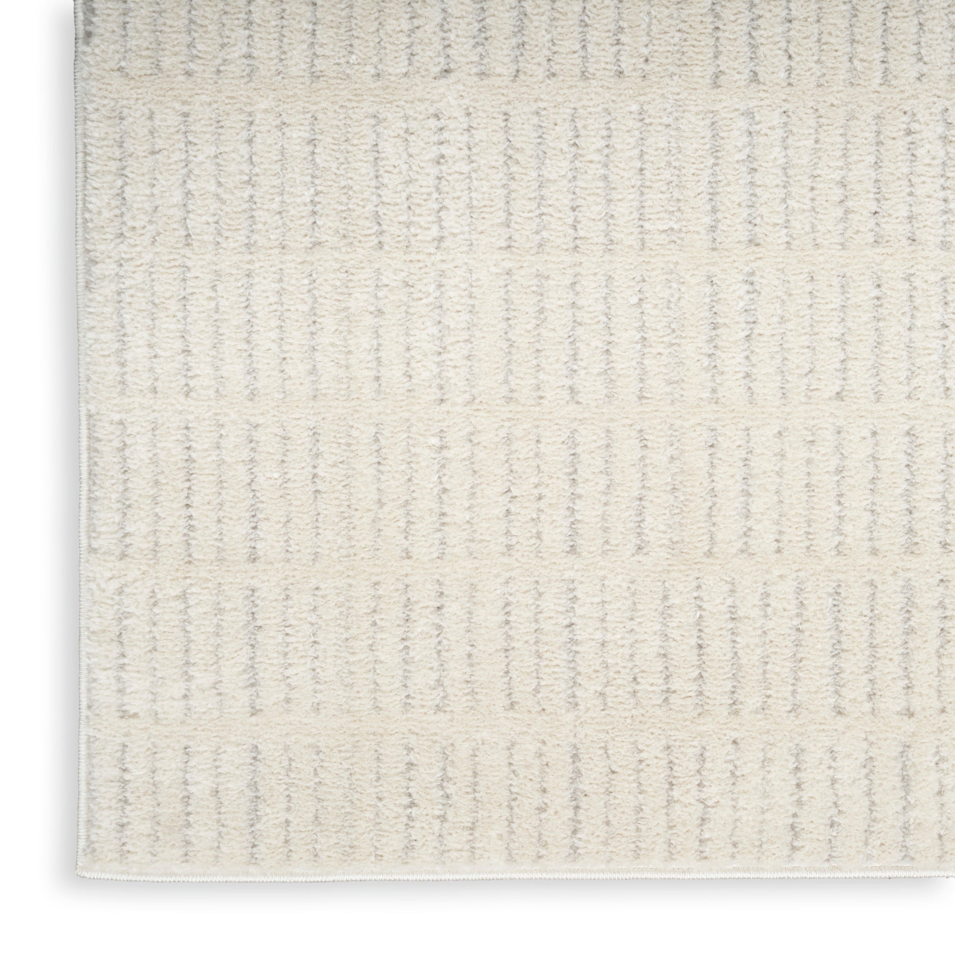 Cream textured rug with vertical ribbed stripes and soft loop pile; neutral bath/entry mat.