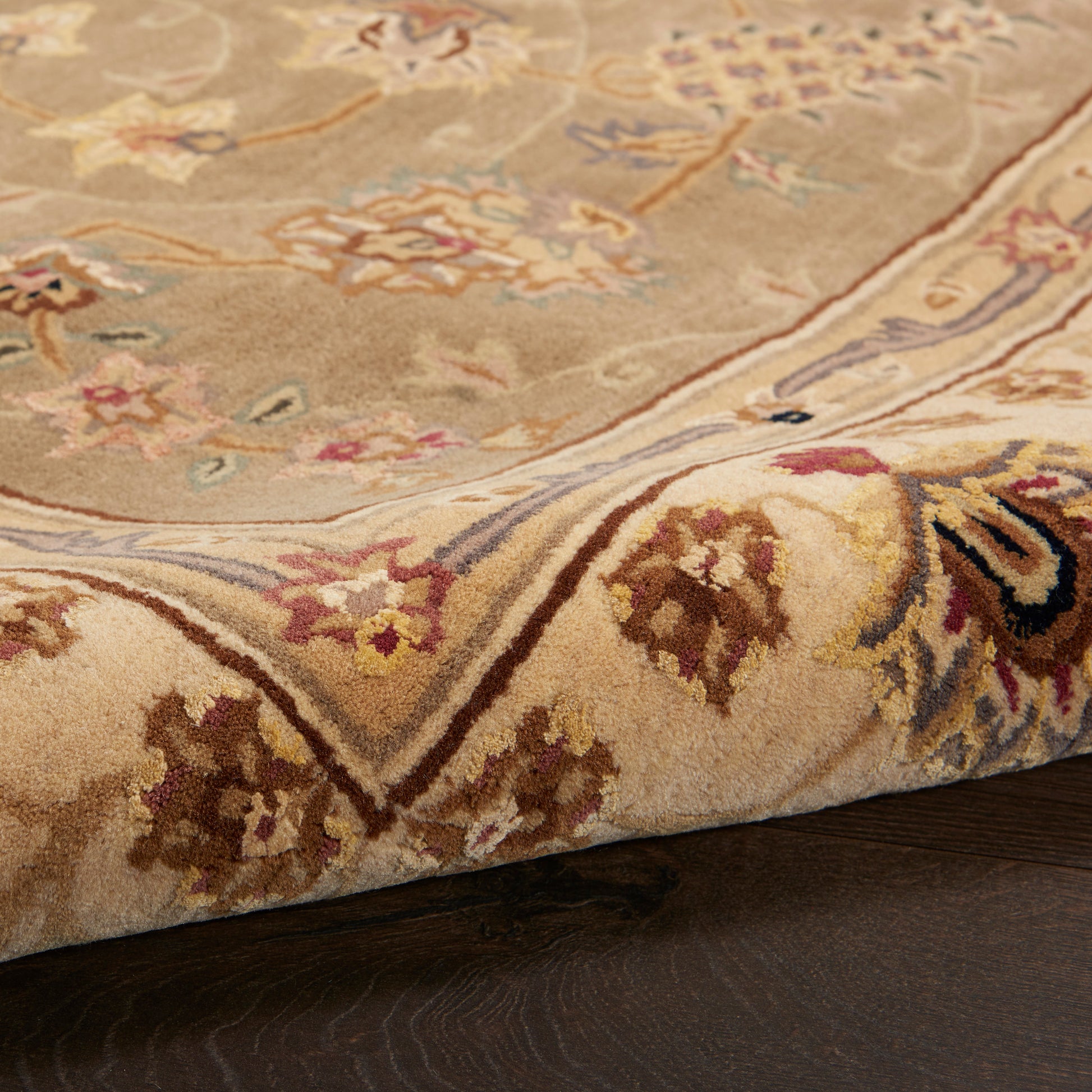 Beige traditional oriental rug with floral motifs in cream, brown, blue and pink; thick pile, folded edge.