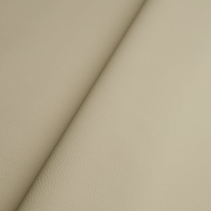 Beige faux leather with fine pebbled texture and a diagonal fold seam.