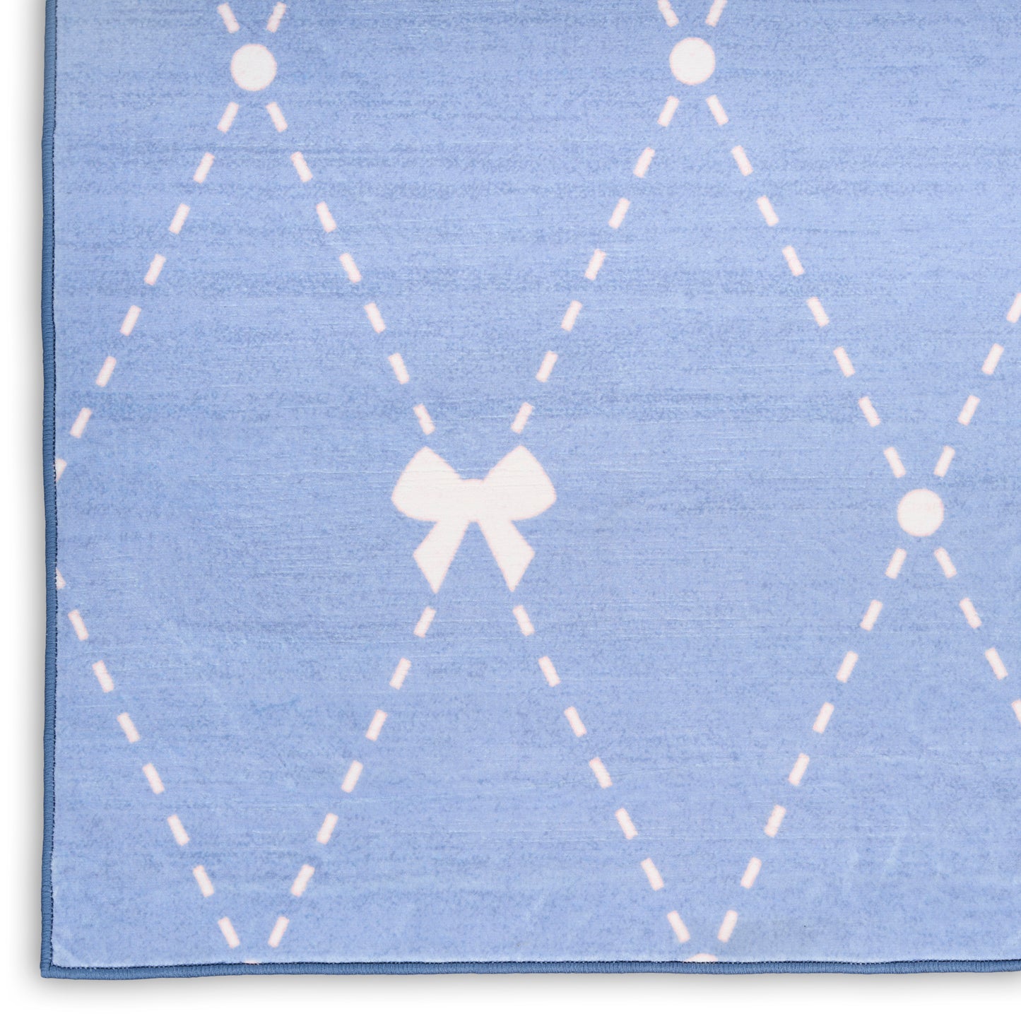 Soft light-blue rug with white dashed argyle diamonds and a centered bow motif.