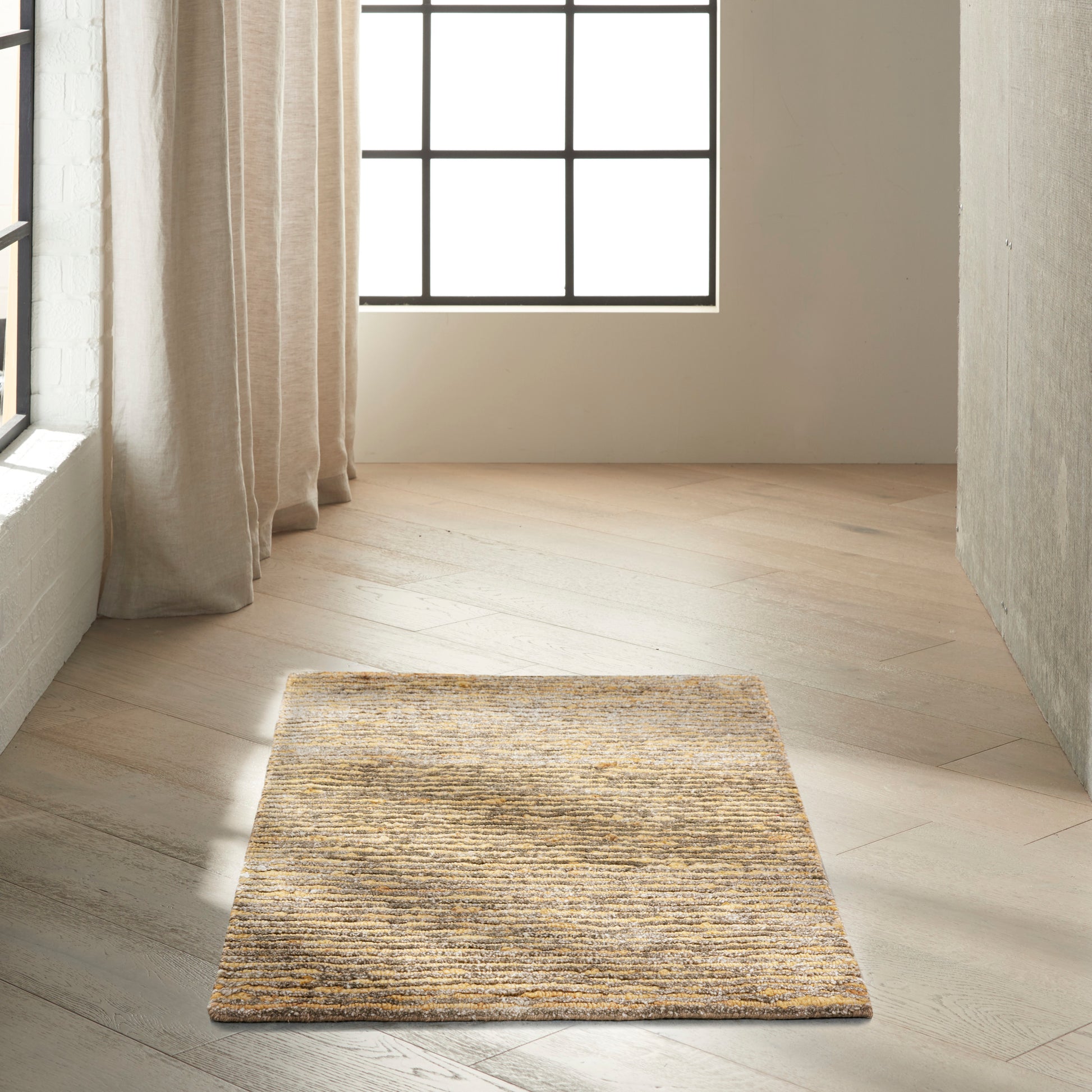 Rectangular natural beige woven jute rug with textured surface on light wood floor by a window.