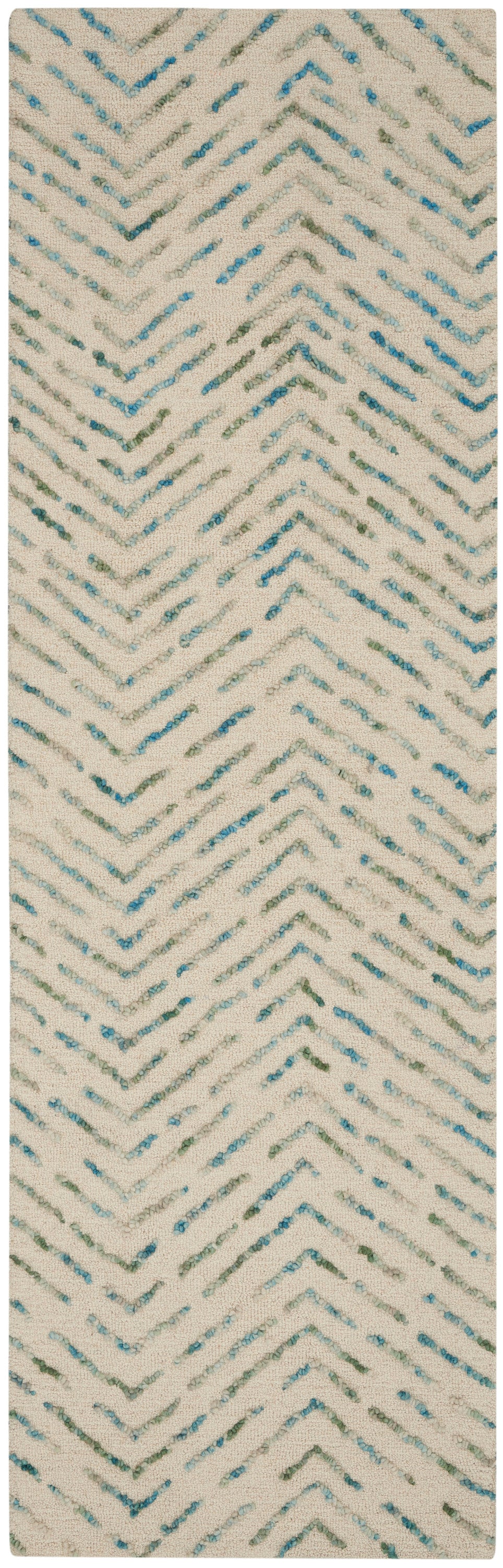 Textured cream rug with aqua teal chevron zigzags and tufted yarn accents.