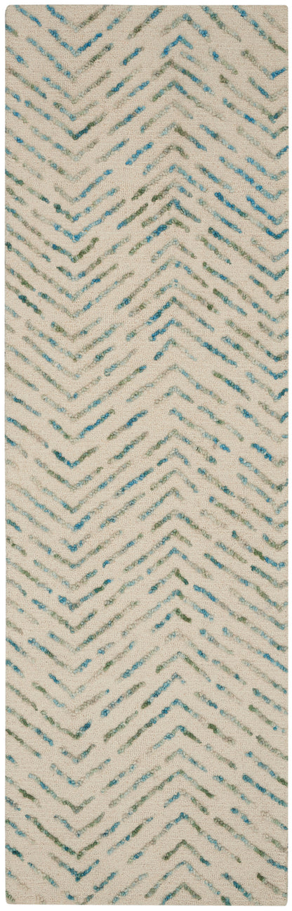 Textured cream rug with aqua teal chevron zigzags and tufted yarn accents.