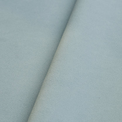 Powder-blue suede-textured fabric with a diagonal fold, soft and plush, suitable for upholstery or crafts.