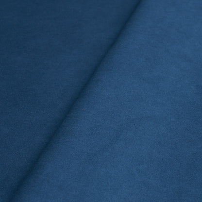 Cobalt blue suede-like fabric close-up with a diagonal fold and soft nap.