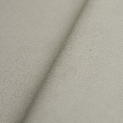 Beige suede-like fabric close-up with a diagonal fold; soft texture for upholstery or apparel.