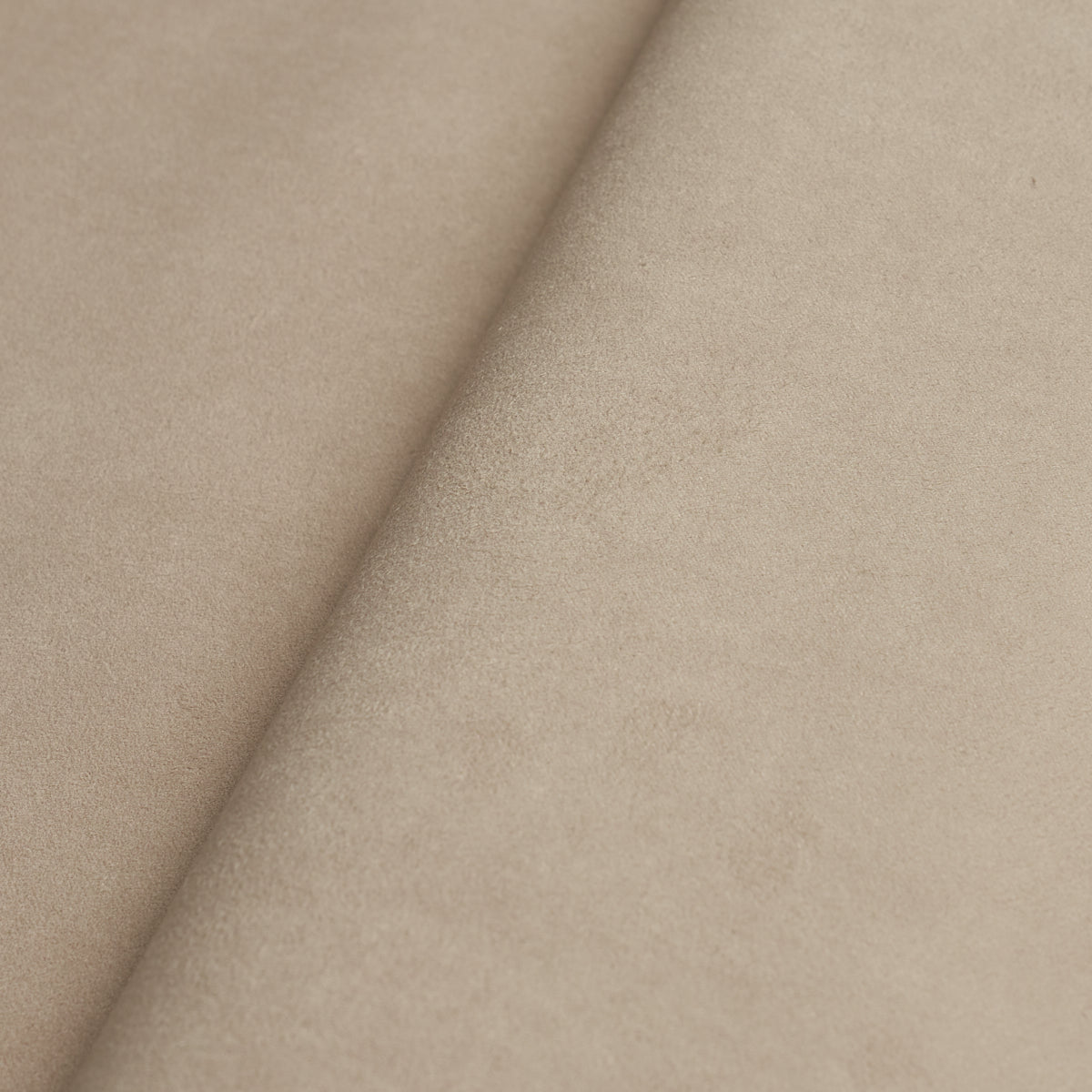 Beige suede-like fabric swatch with soft nap and diagonal fold, warm neutral tone for upholstery or crafts.