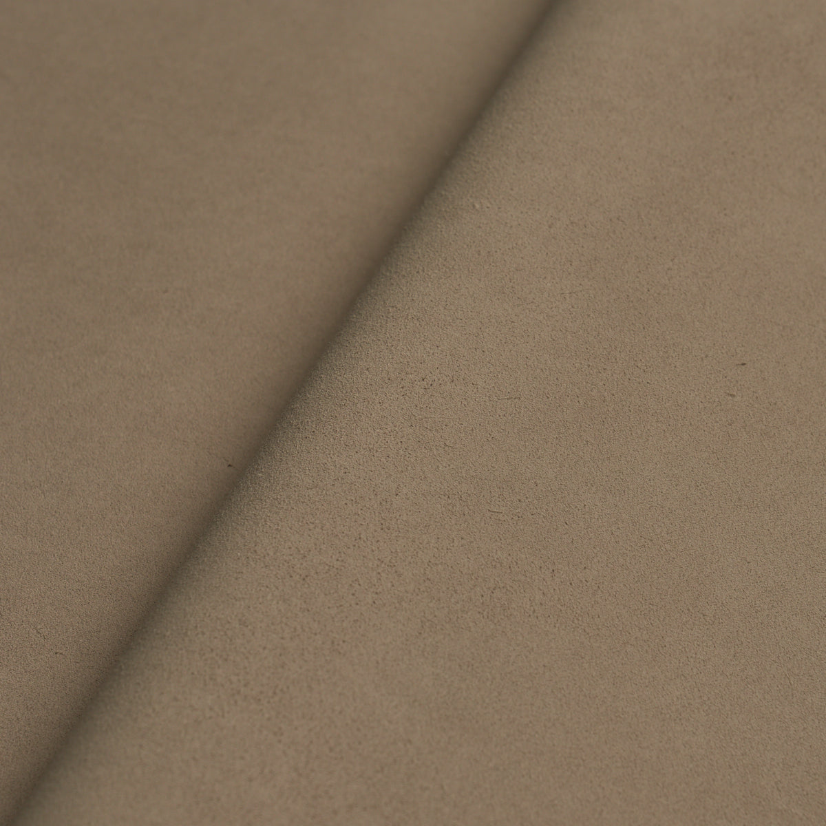Tan suede fabric roll with a diagonal fold, soft nap and matte finish.