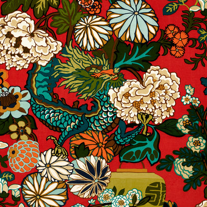 Vibrant red fabric with colorful floral print and blue dragon motif; decorative textile for fashion or upholstery.