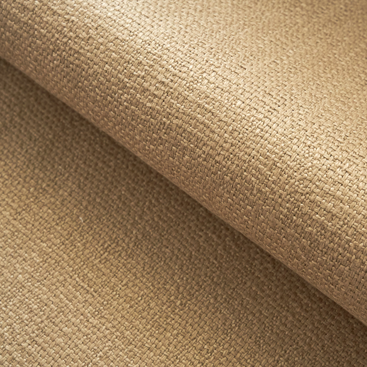 Beige woven fabric close-up with a tight grid-like weave; rolled sheet, natural rustic upholstery or craft material