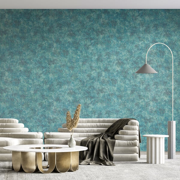 Modern living room with turquoise textured wall, white sofa, round coffee tables with gold bases, arc floor lamp.