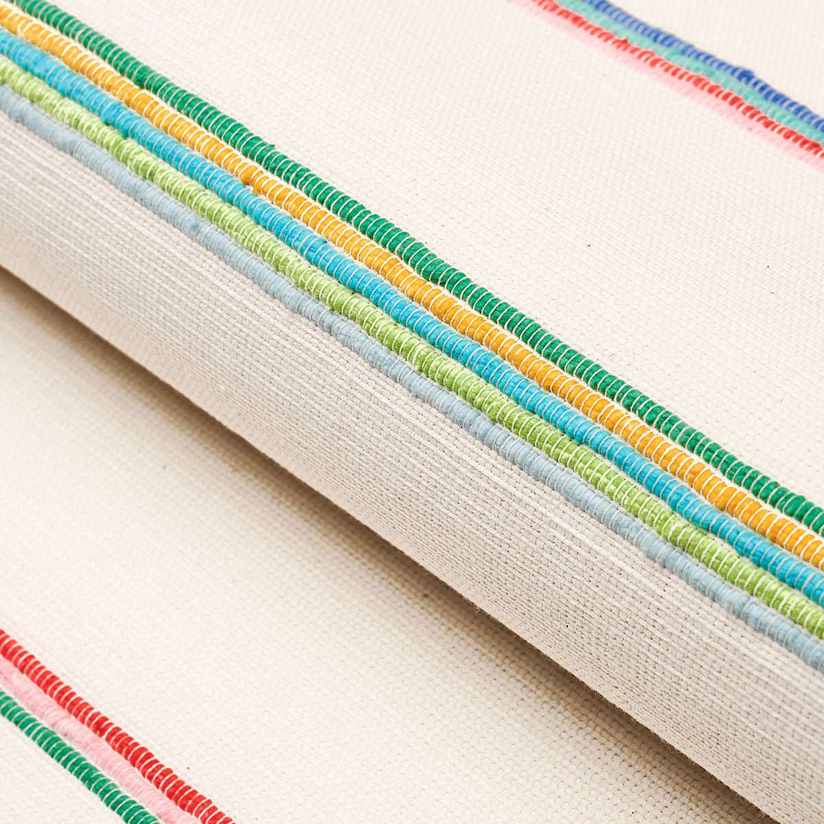 Beige canvas with multicolor embroidery trim along edge in green, blue, yellow & orange; casual decorative textile detail.