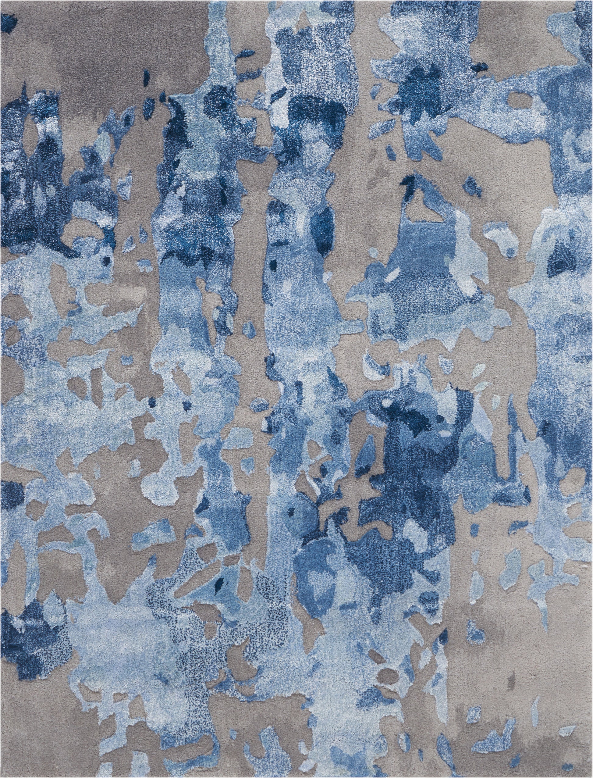 Abstract blue-toned area rug with irregular azure patches on a warm gray-beige backdrop; modern contemporary design.