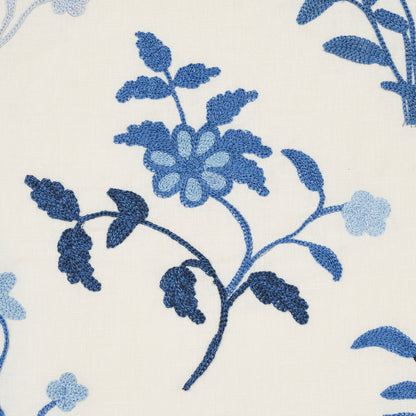Cream fabric with blue embroidered floral pattern; Navy and light-blue blossoms and stems.