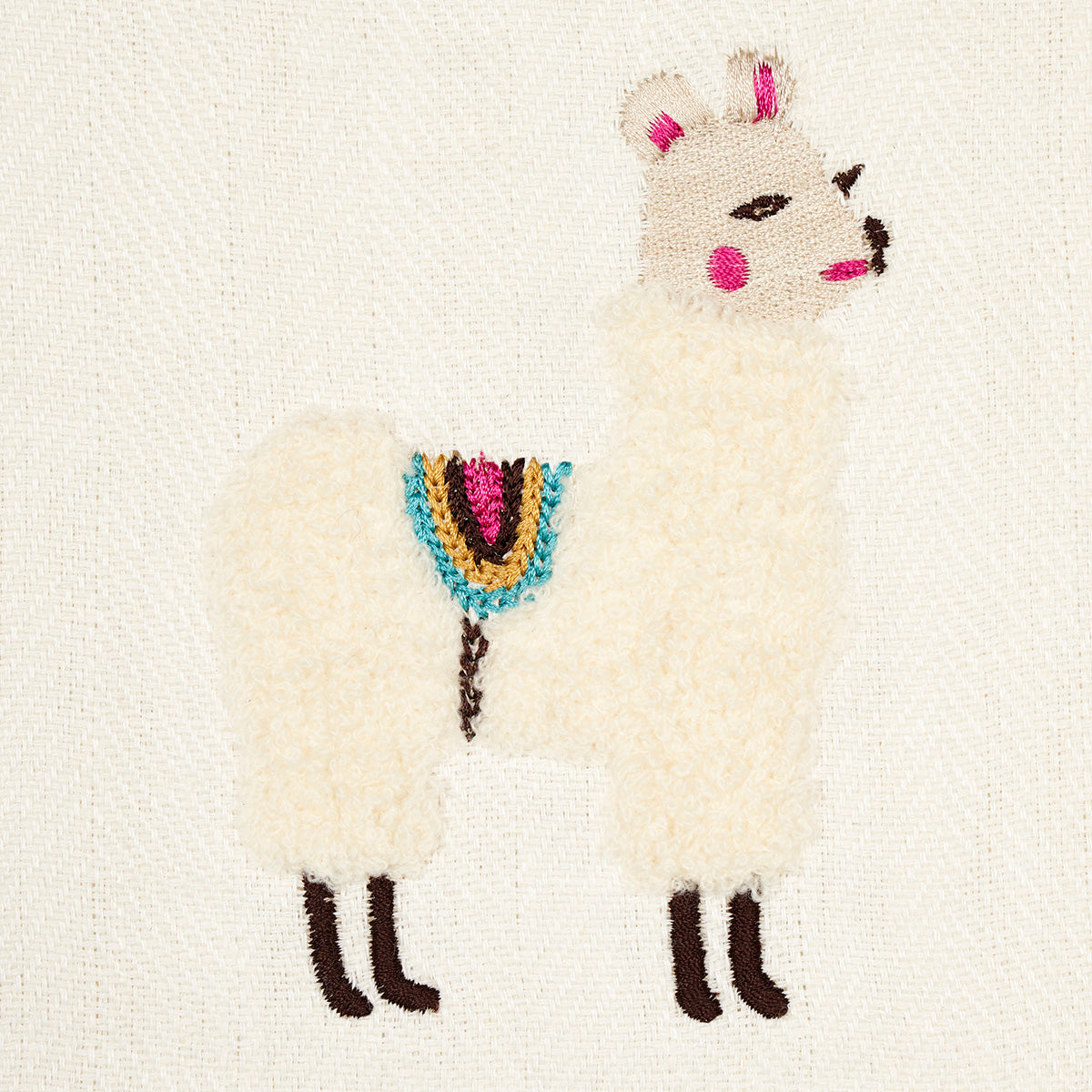 Cream llama embroidery on canvas with pink ears and cheeks, brown hooves, multicolor saddle blanket; rustic stitch art.