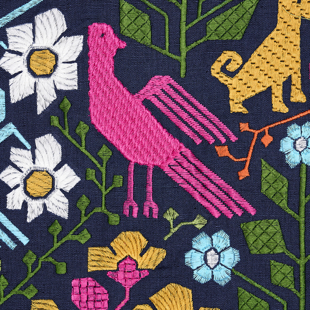 Embroidered navy fabric with pink bird, yellow leopard, white daisies, blue flowers and green foliage.