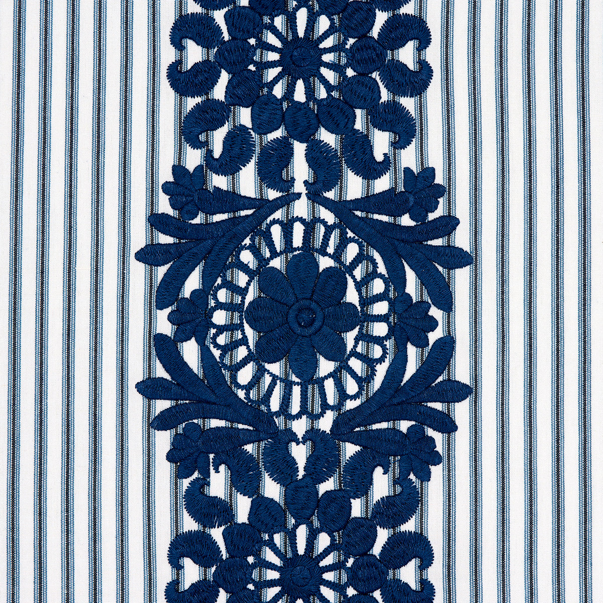 Deep blue embroidered lace panel featuring circular floral medallion and leaf motifs on striped blue-and-white fabric.