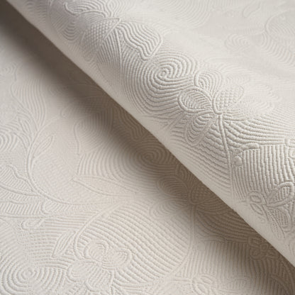 Cream damask jacquard fabric with embossed floral scroll pattern and textured finish.