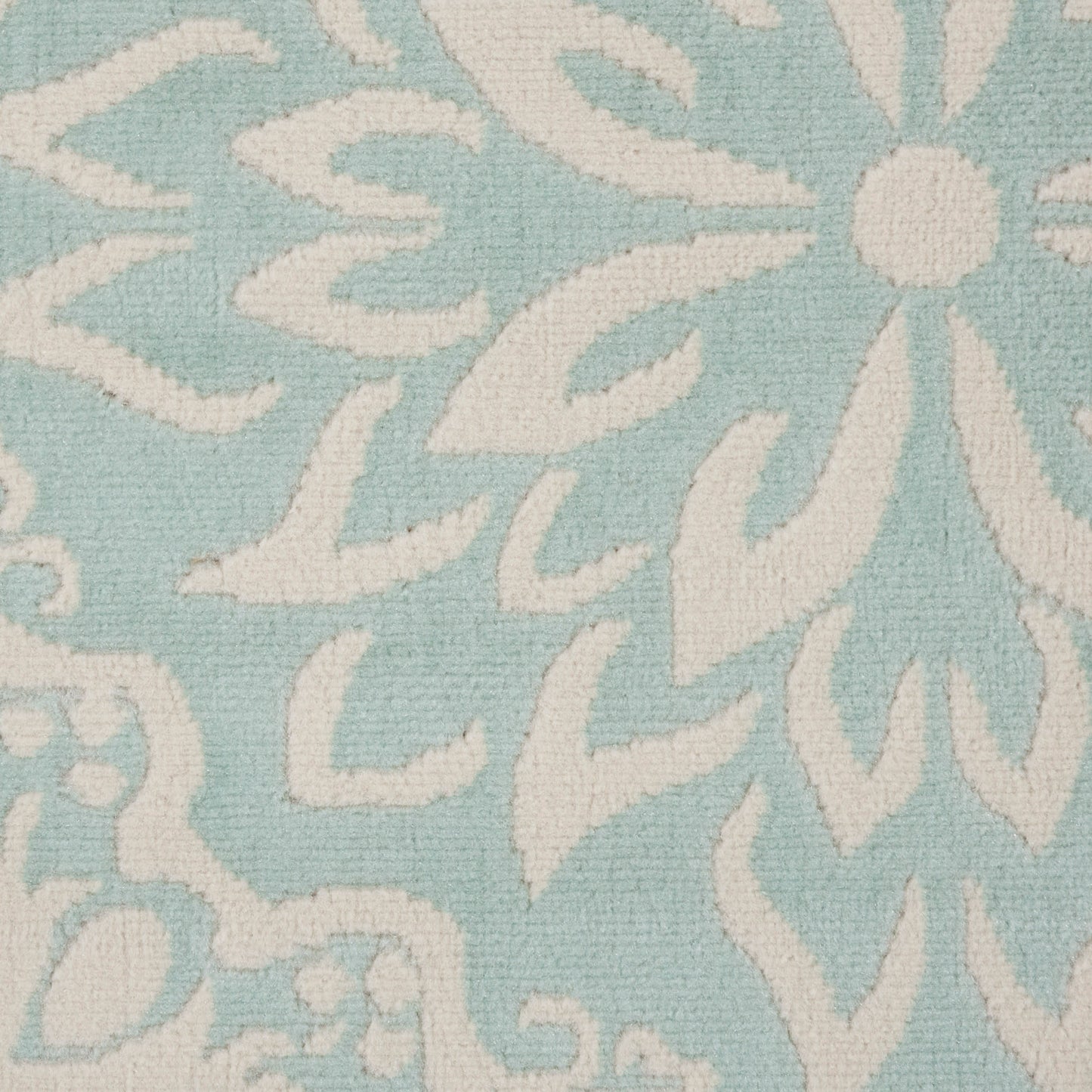 Light blue woven rug with a white damask floral pattern; elegant floor rug.