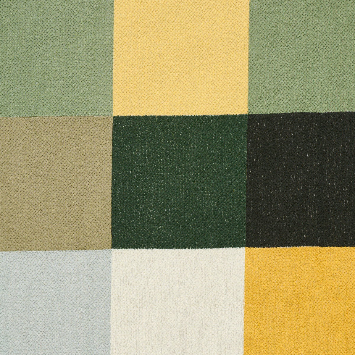 Patchwork woven fabric with nine square color blocks in greens, yellows, taupe and pale blue.