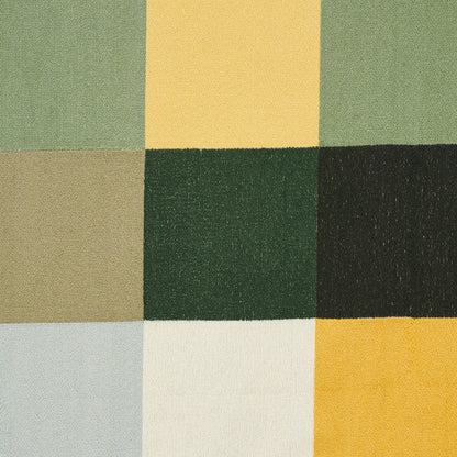 Patchwork woven fabric with nine square color blocks in greens, yellows, taupe and pale blue.