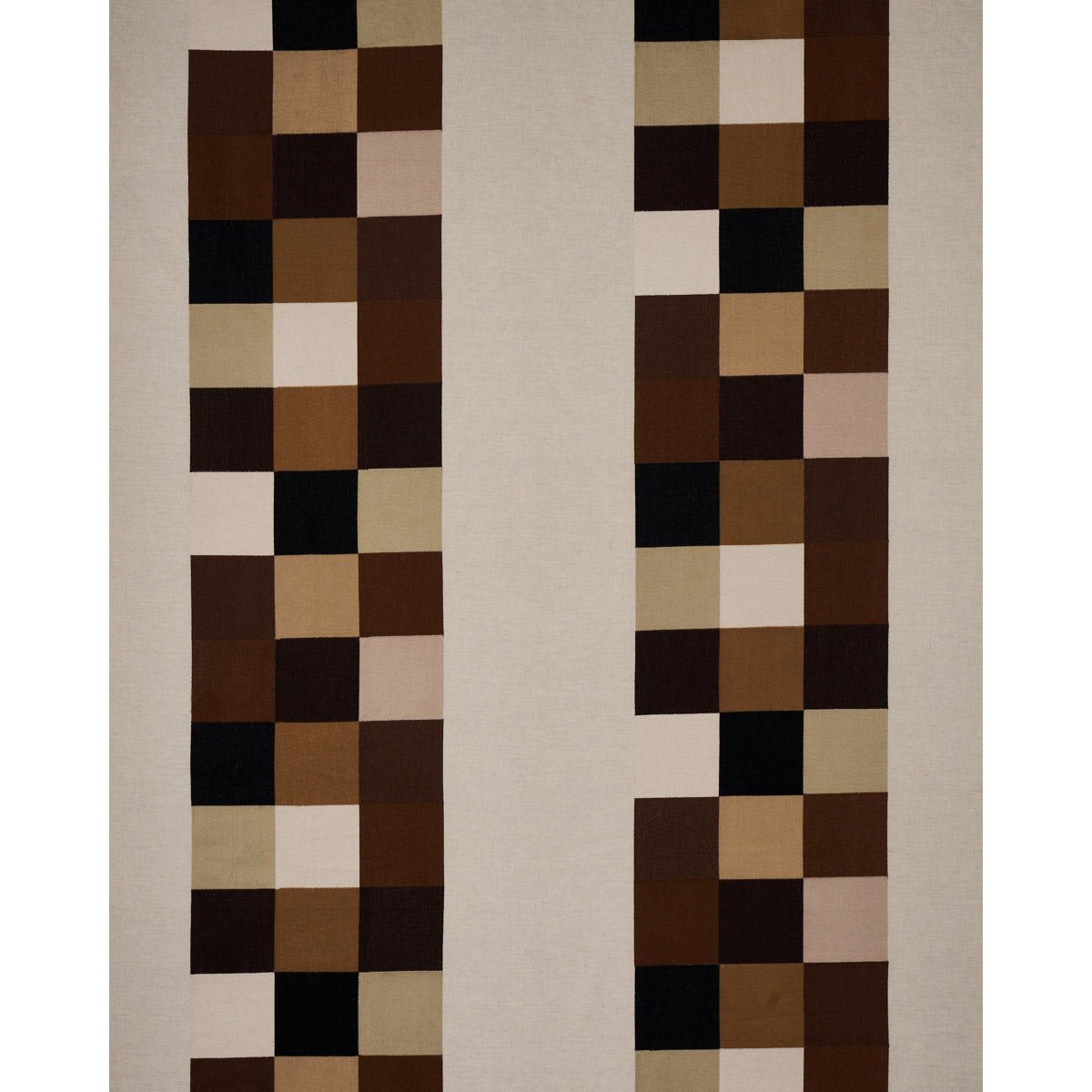 Geometric beige rug with two vertical columns of brown, tan and cream squares on a light background.