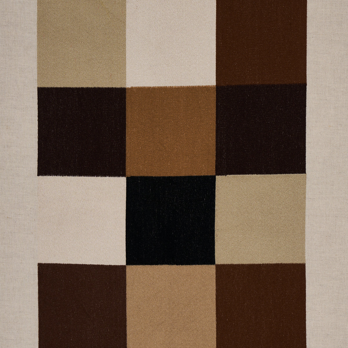 Embroidered tile pattern on fabric in strong neutral tones.