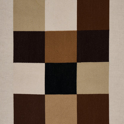 Embroidered tile pattern on fabric in strong neutral tones.