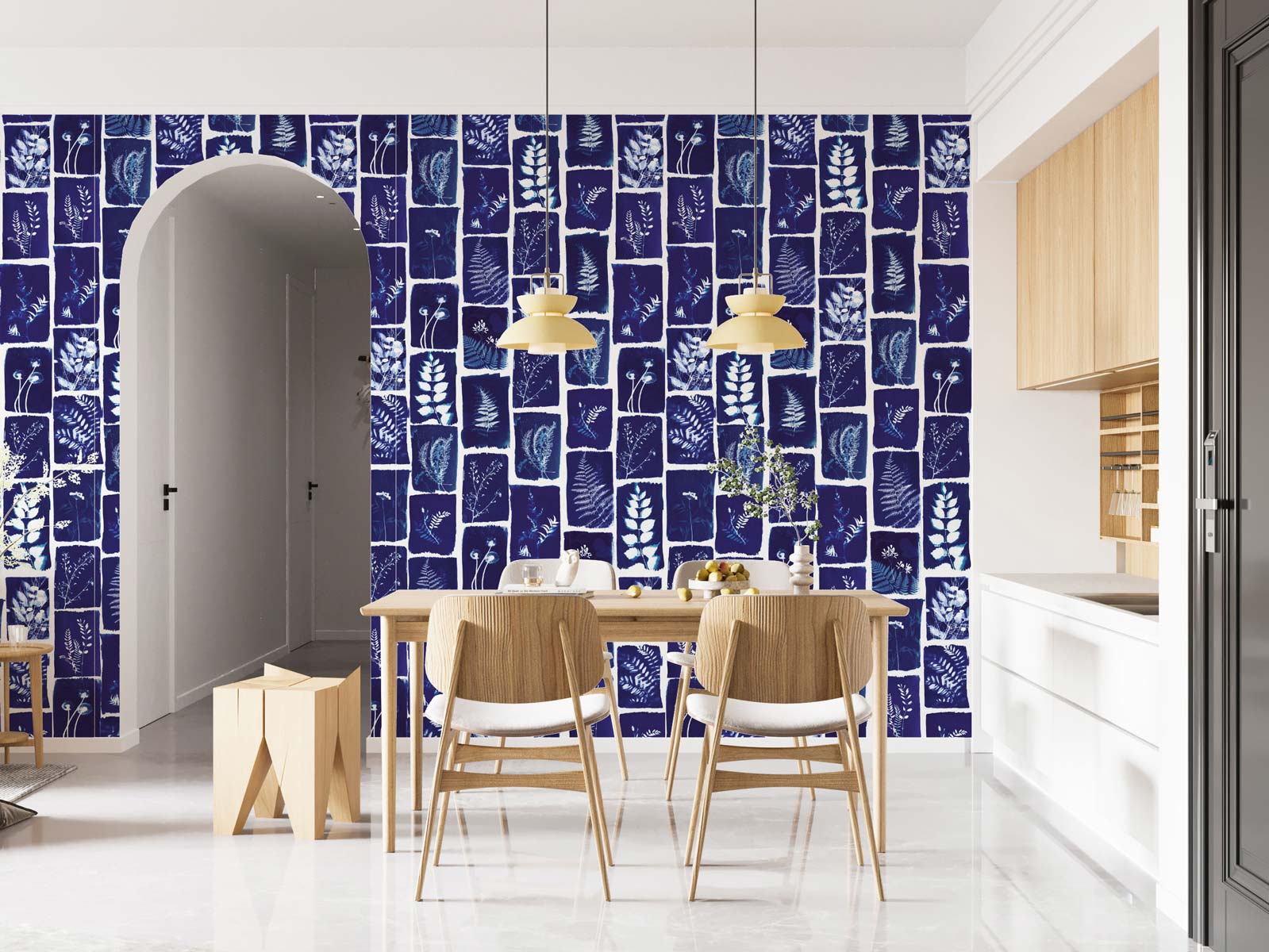 Dining area featuring navy botanical-pattern wall mural, with light wood table and chairs, pendant lights, arch doorway and white kitchen.