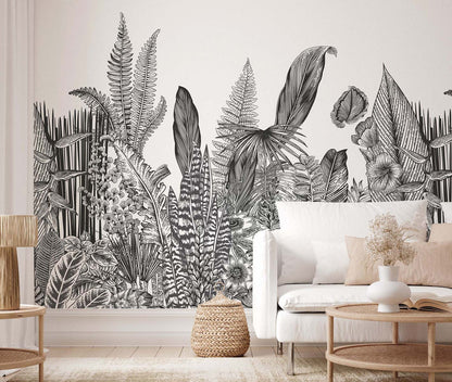 Living room with a black-and-white tropical plant mural, white sofa, and light-wood coffee table.