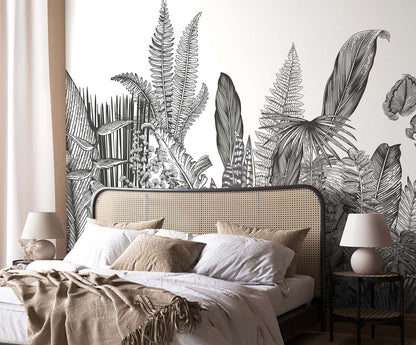 Bedroom with large black-and-white fern mural, beige upholstered bed, white and beige linens, two round bedside lamps.