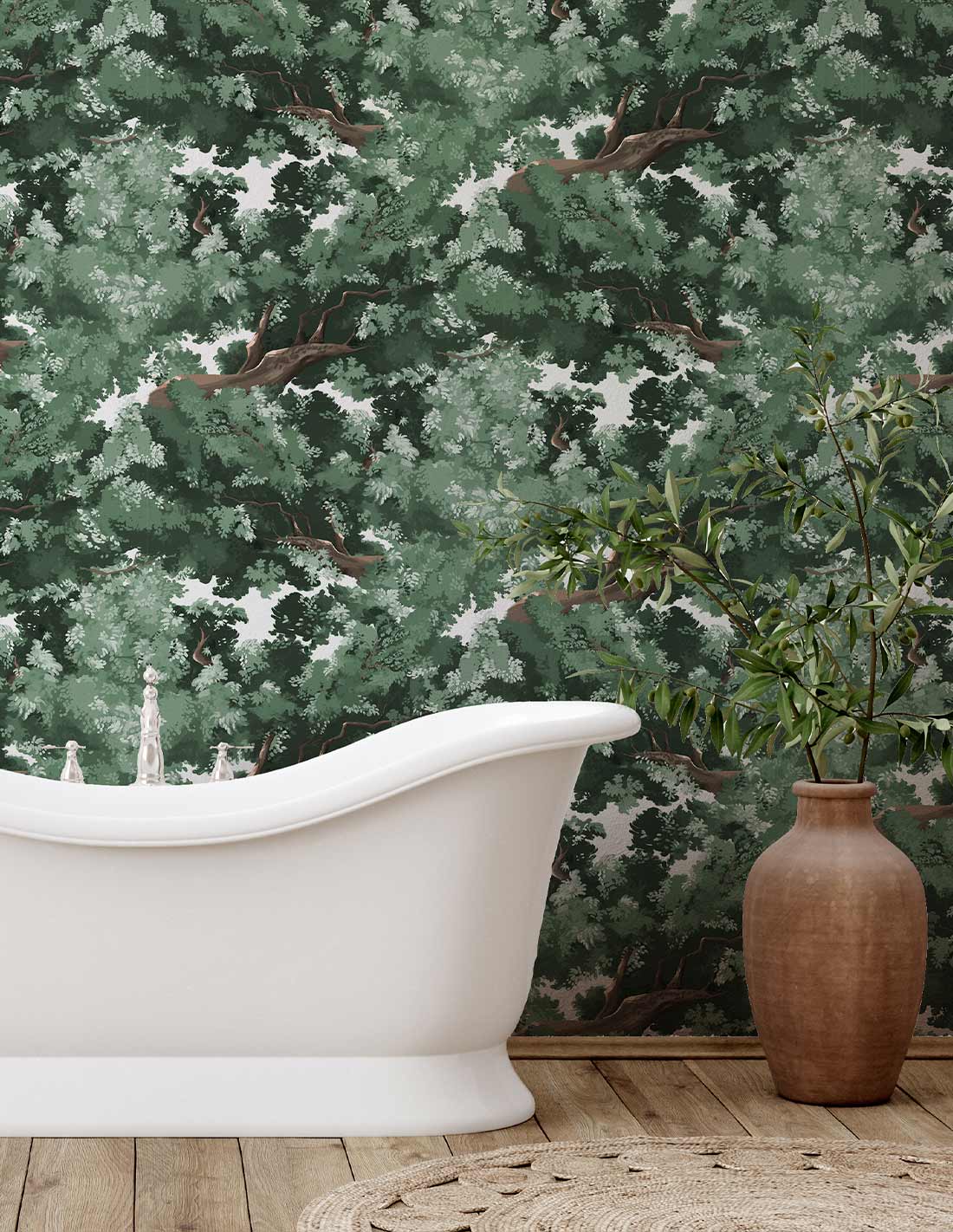White freestanding bathtub with curved rim on a wooden floor, tall brown vase with greenery & a green leafy wall mural.