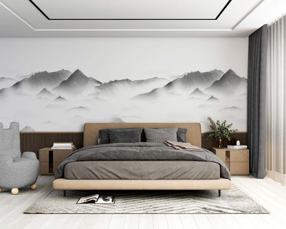Modern bedroom featuring a gray nature wall mural with mountains, beige platform bed, gray duvet & pillows, tan headboard, wood nightstands, gray curtains.