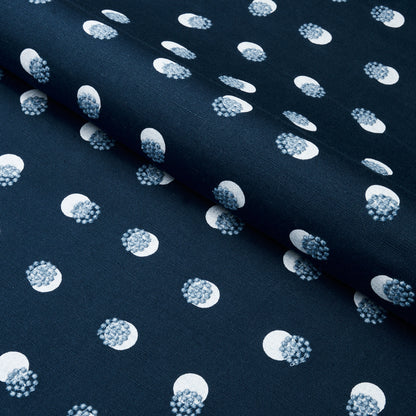 Navy fabric with white-ringed polka dots and blue speckled centers; soft woven textile for garments or crafts.