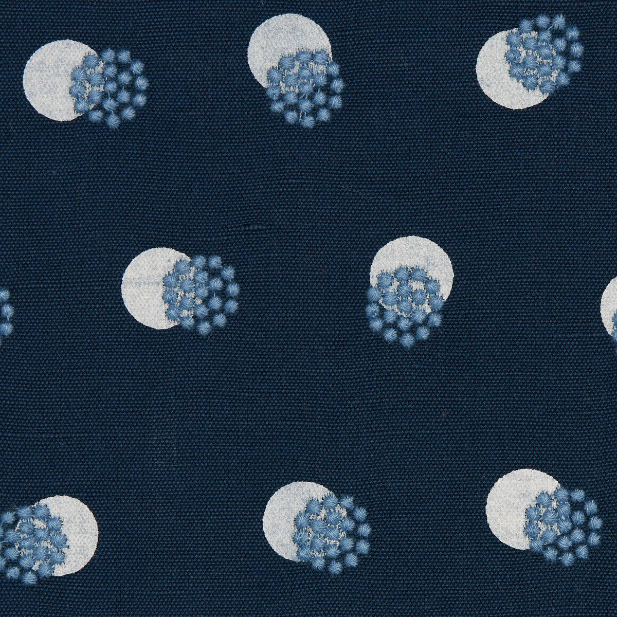 Navy fabric featuring repeating white circles overlapped by blue spiky virus-like clusters on a woven backdrop.
