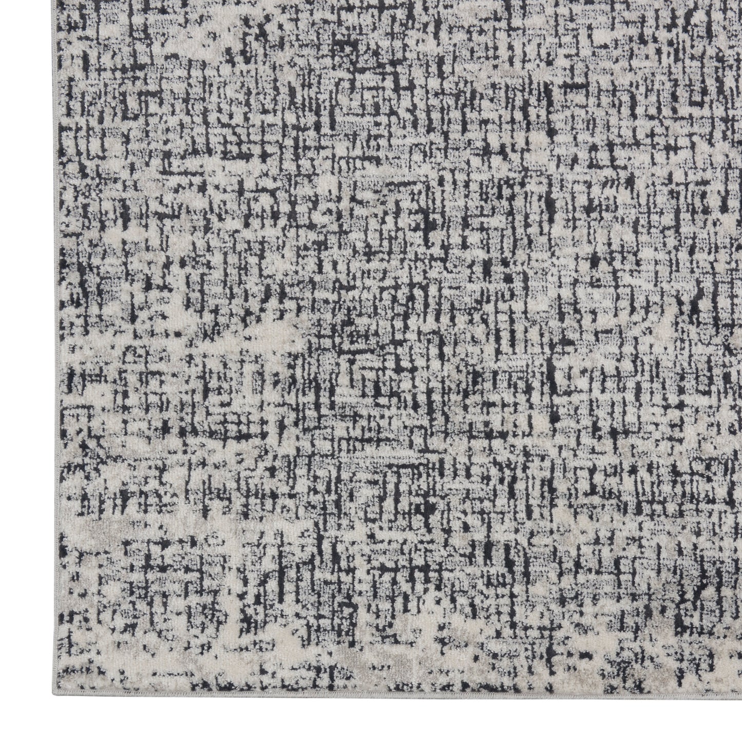 Rectangular distressed rug in charcoal, grey and ivory with a modern abstract pattern.