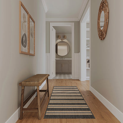 Neutral hallway with wood floor and a modern striped 8' runner rug; woven-seat bench; wicker round mirror, leading to a bathroom vanity.