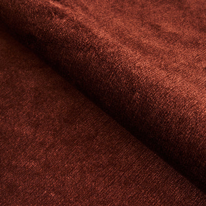 Rust-red velvet fabric close-up with soft pile and folded drape.