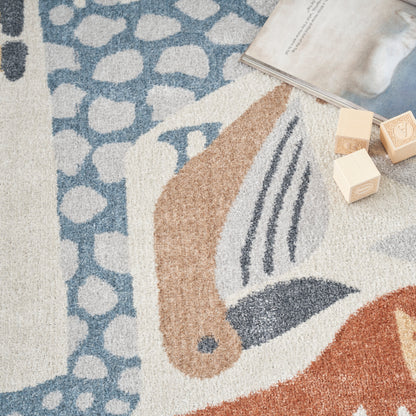 Soft, shaggy abstract-pattern area rug in blue, beige and orange with wooden blocks and an open magazine.