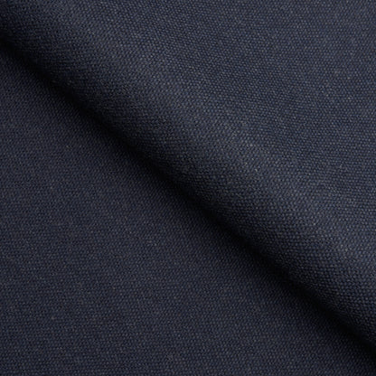 Close-up of dark navy woven fabric with a diagonal fold and tight textured weave, ideal for garments.