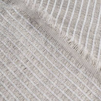 Beige striped woven rug with white fringe edge; soft cotton throw for living room decor.