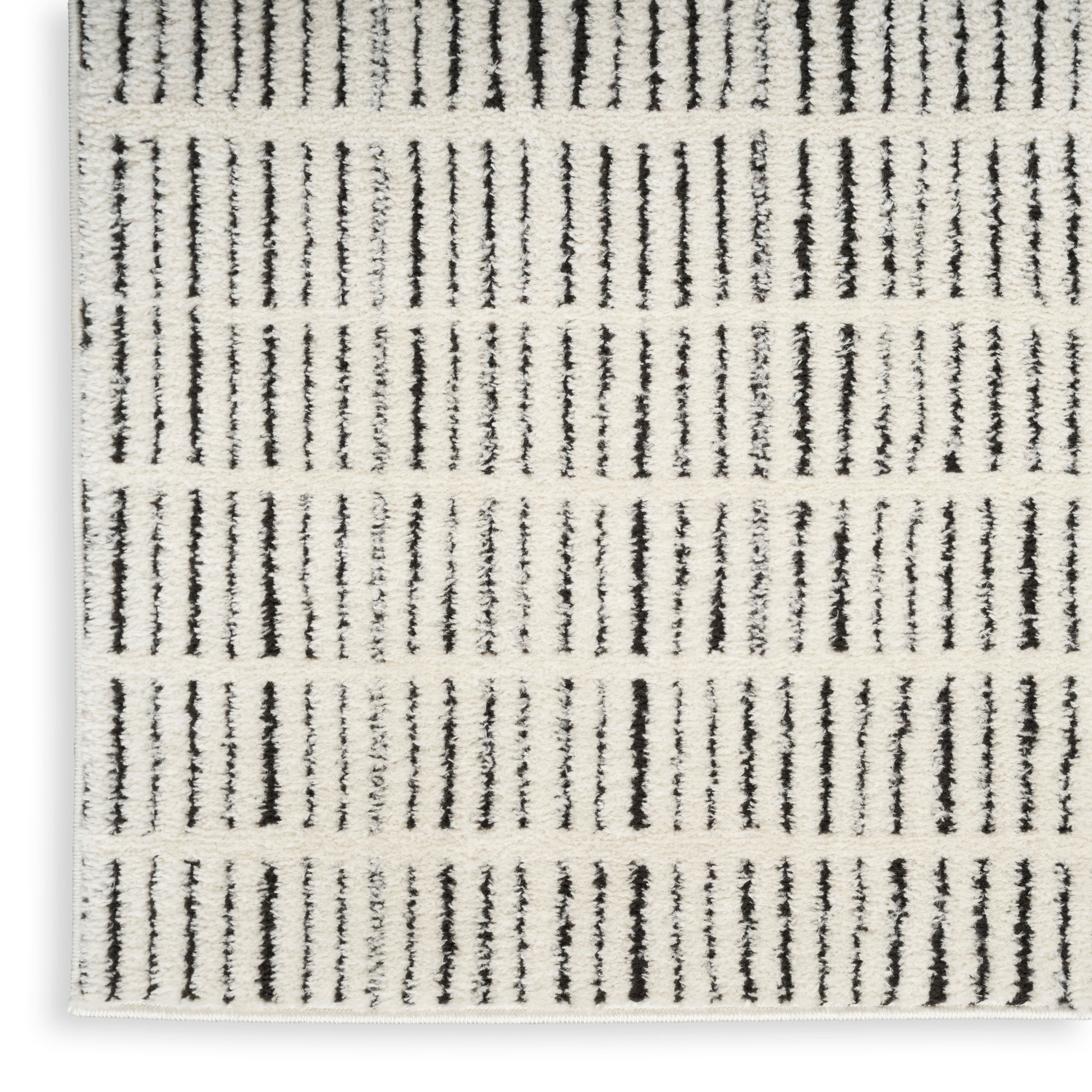 Beige woven area rug with narrow black vertical stripes; low-pile, rectangular, modern minimalist decor.