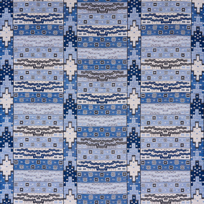 Blue woven rug with light to dark blue stripes, white geometric diamonds and small floral motifs.