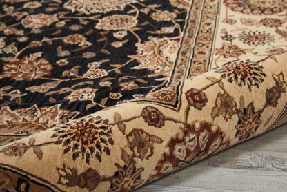 Persian-inspired area rug with a dark central field and ivory floral motifs, beige-red border, rolled on a wooden floor.