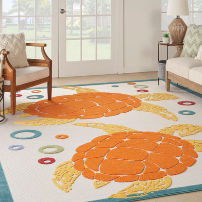 Bright rectangular area rug with orange turtle shells, yellow accents, white background, teal border, in a cozy living room.