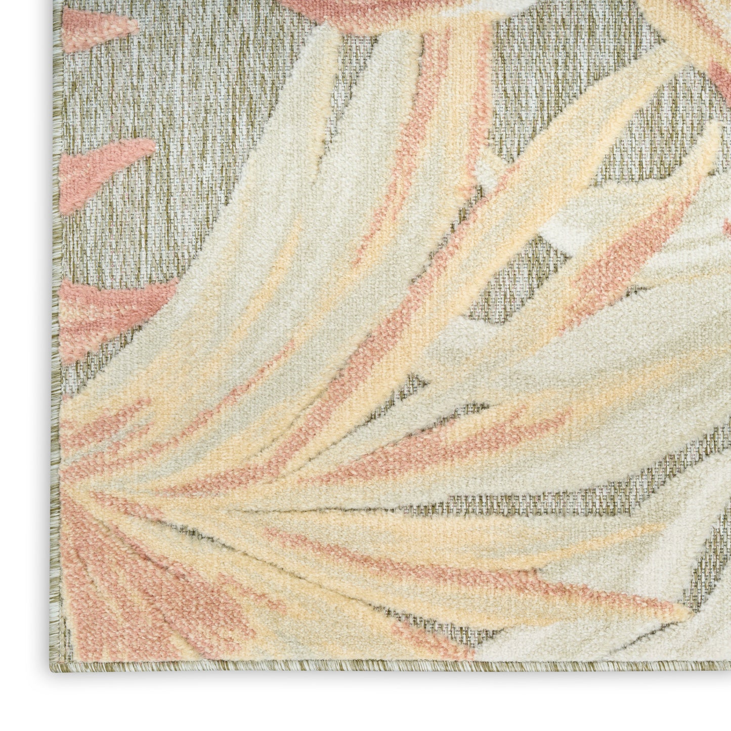 Close-up of a textured tufted rug with abstract cream, peach and pastel yellow leaf shapes on a grey background.