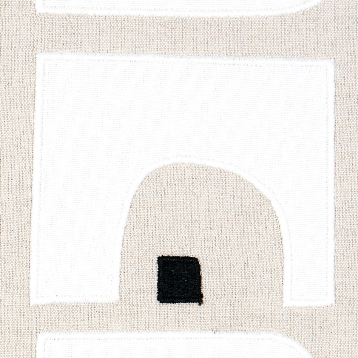 Beige fabric with white geometric panels and a small black square, modern abstract textile for decor.